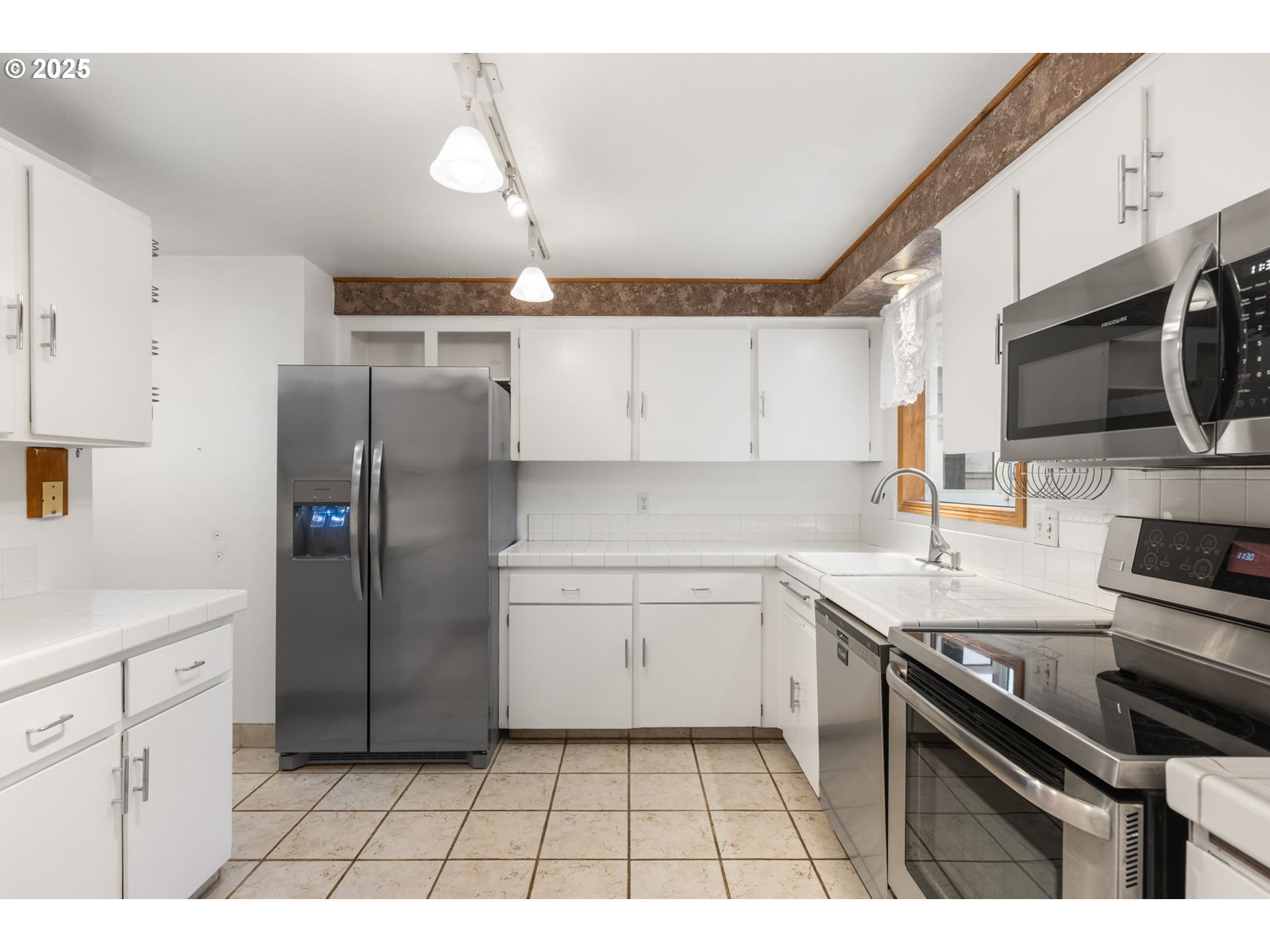 17130 Southwest Baker Street Beaverton, OR 97007 - Photo 20 of 37 a kitchen with a sink a refrigerator and a stove