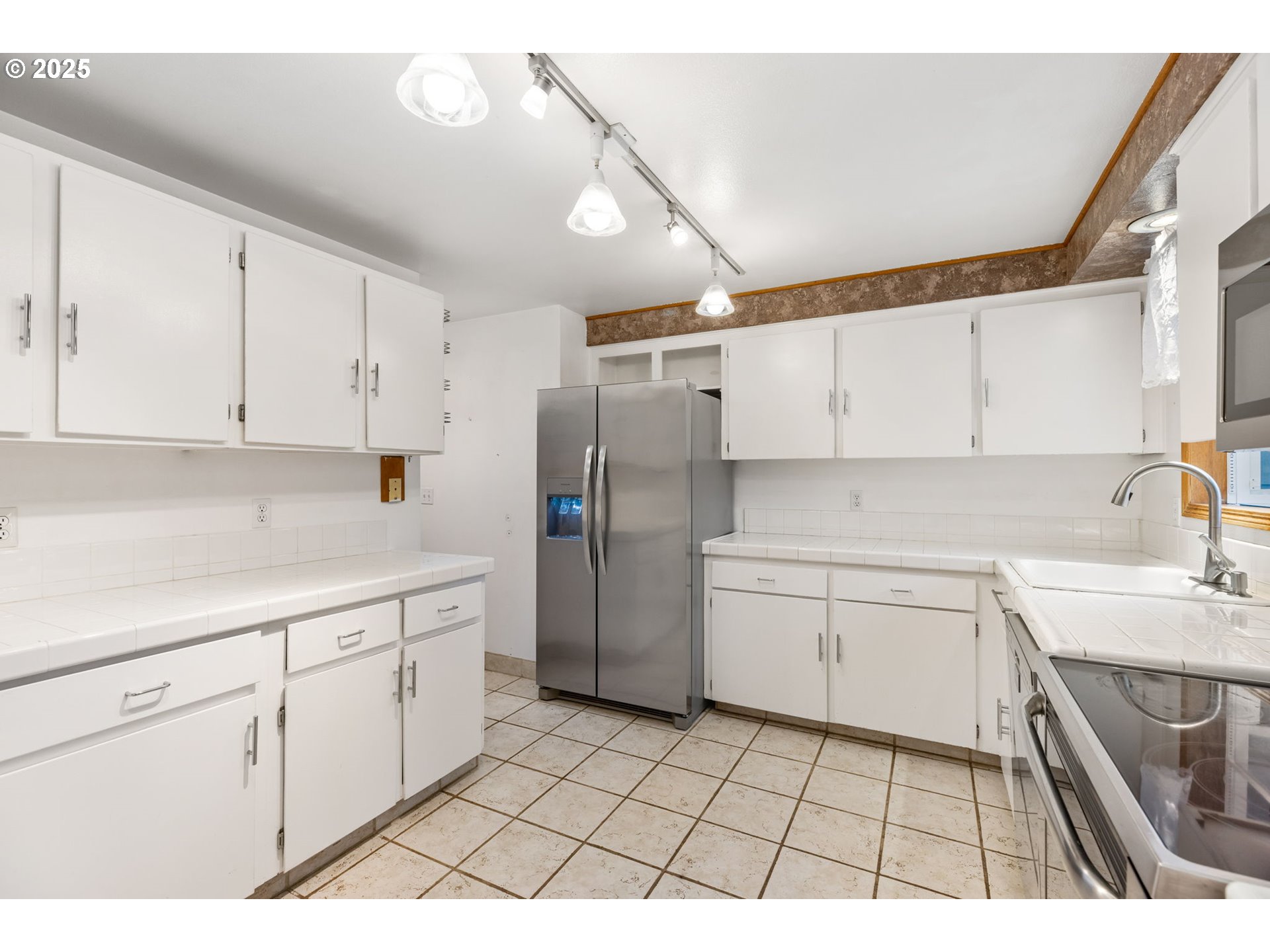 17130 Southwest Baker Street Beaverton, OR 97007 - Photo 21 of 37 a kitchen with a sink a refrigerator and cabinets