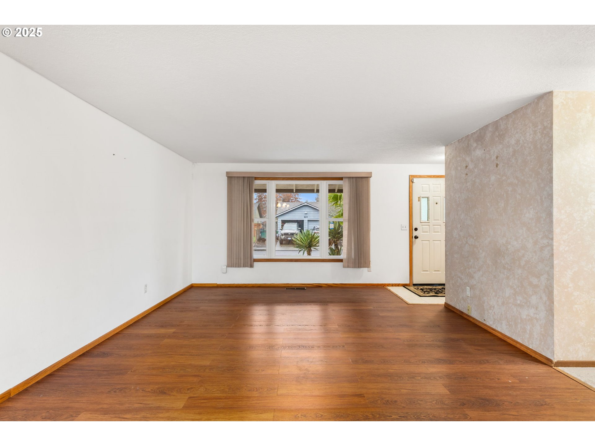 17130 Southwest Baker Street Beaverton, OR 97007 - Photo 8 of 37 a view of an empty room with window and wooden floor
