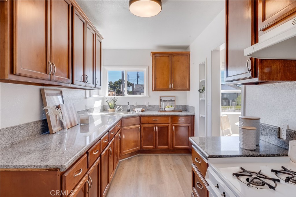 1347 East Bennett Street Compton, CA 90221 - Photo 3 of 31 a kitchen with stainless steel appliances granite countertop a sink stove and cabinets