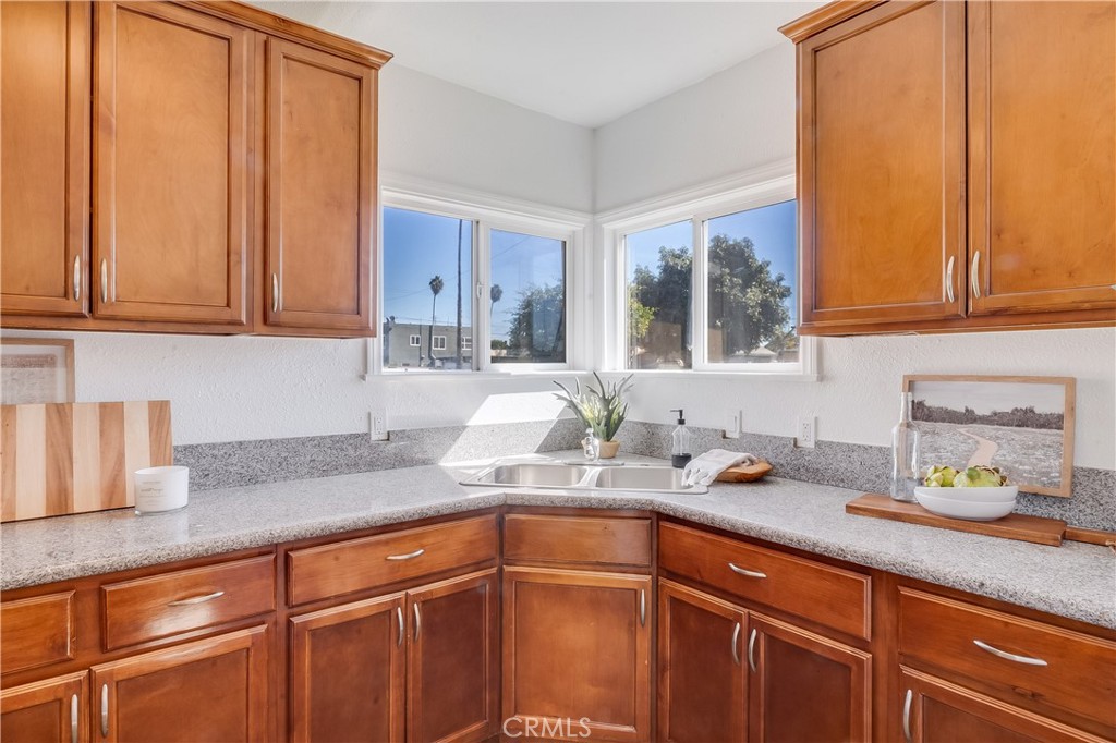 1347 East Bennett Street Compton, CA 90221 - Photo 10 of 31 a kitchen with stainless steel appliances granite countertop a sink a refrigerator and cabinets