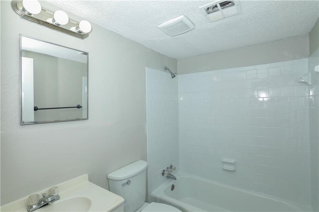 2065 Alison Court Southwest, Unit 6 Atlanta, GA 30311 - Photo 11 of 14 a white toilet sitting next to a bath tub