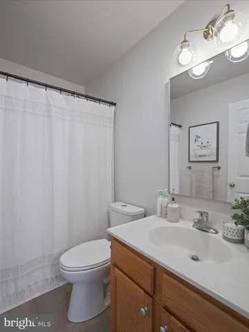 a bathroom with a sink vanity mirror and toilet
