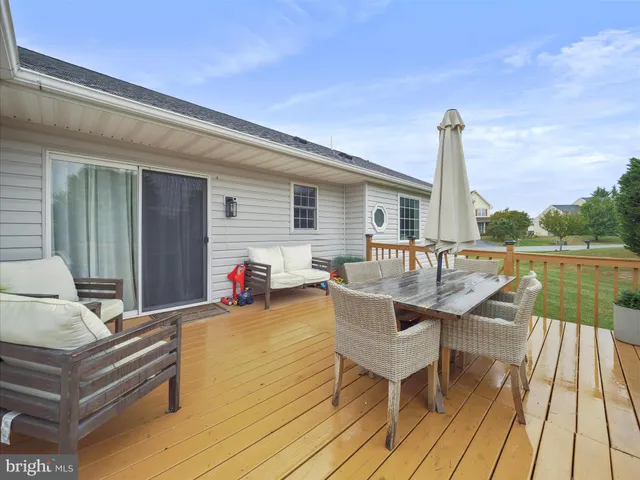 a view of a roof deck with table and chairs a barbeque with wooden floor and fence