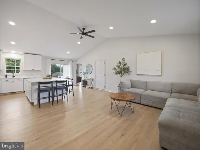 a living room with furniture and view of kitchen