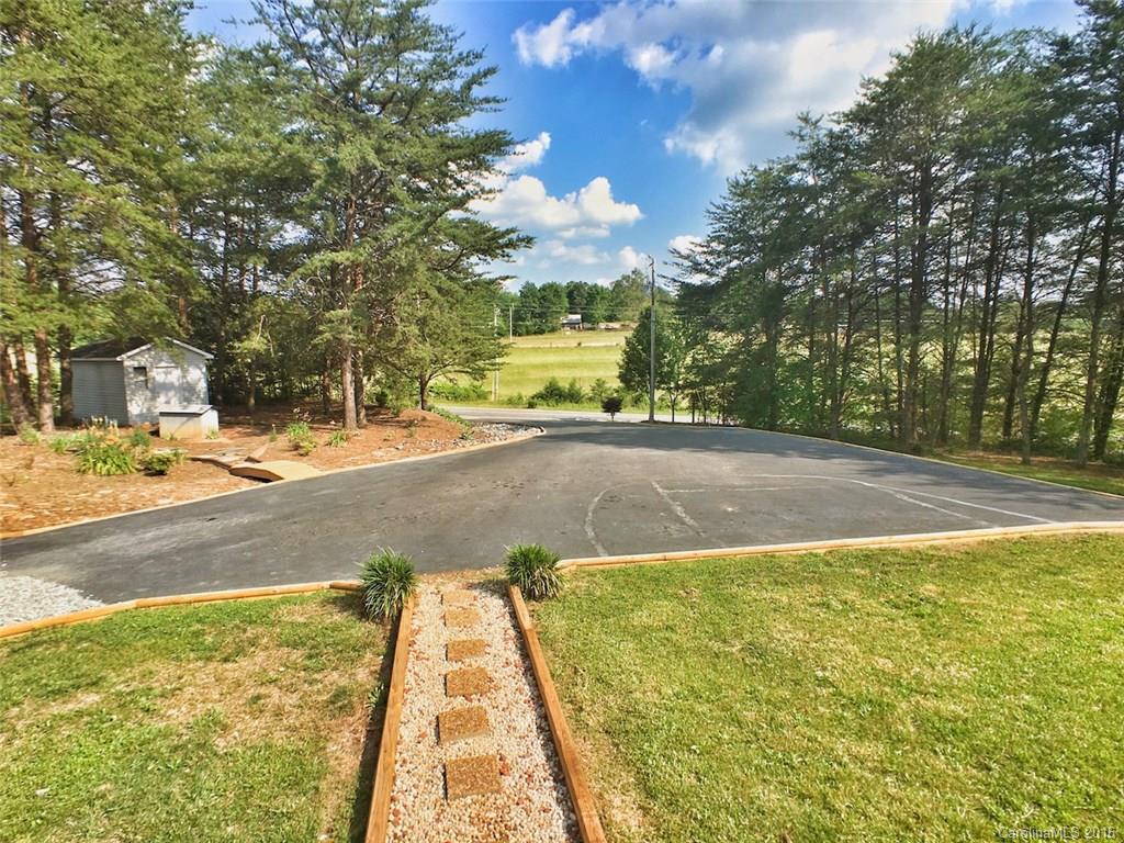 5563 South Wilson Hill Road Mill Spring, NC 28756 - Photo 7 of 18 a view of a yard with yellow house