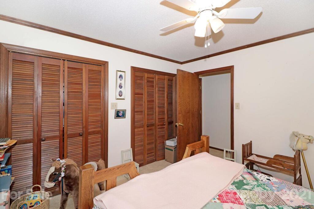 517 Old Pageland Monroe Road Monroe, NC 28112 - Photo 24 of 48 a bedroom with a bed and a chandelier