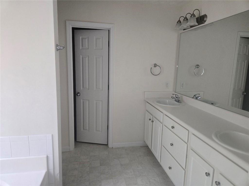 22 Windcrest Keep Covington, GA 30016 - Photo 20 of 32 a spacious bathroom with a double vanity sink a mirror and a bathtub