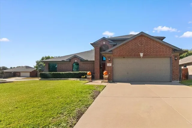 a front view of house with yard and mountain view in back