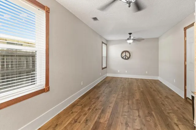 a view of a room with a window and wooden floor