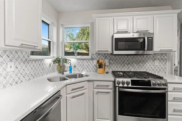 a kitchen with cabinets stainless steel appliances and a sink