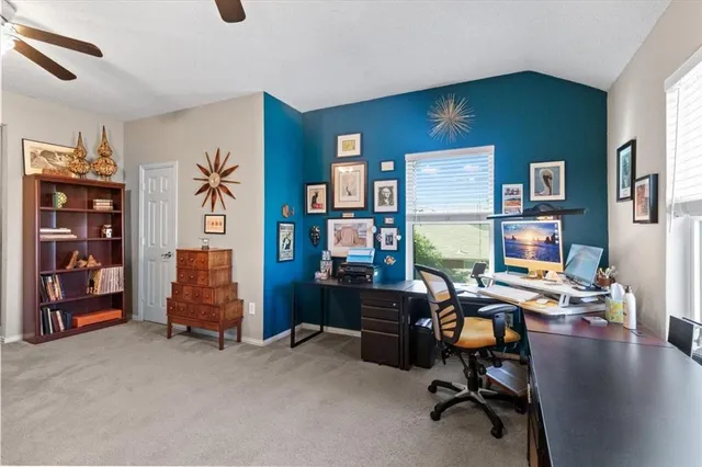 a view of a workspace with furniture and a window