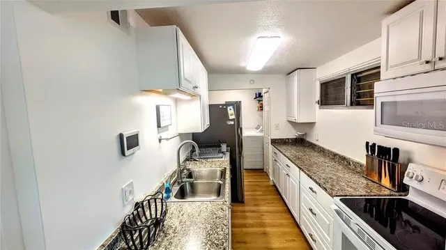 a kitchen with granite countertop a stove and a sink