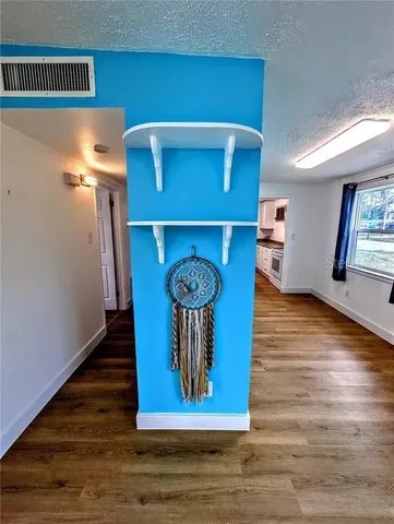 a room with wooden floor and a rug