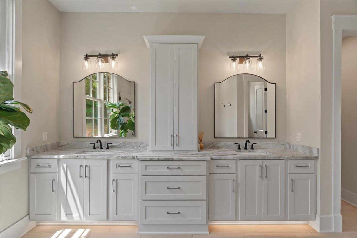240 Burrows Road Collierville, TN 38017 - Photo 16 of 37 Dual vanity with white cabinetry, light-toned countertops, and under-cabinet lighting