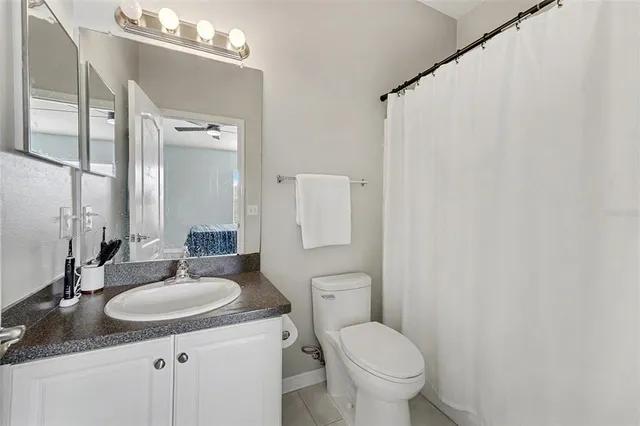 a bathroom with a granite countertop sink toilet and a mirror