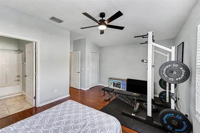 a bedroom with bed and a clock on the dresser
