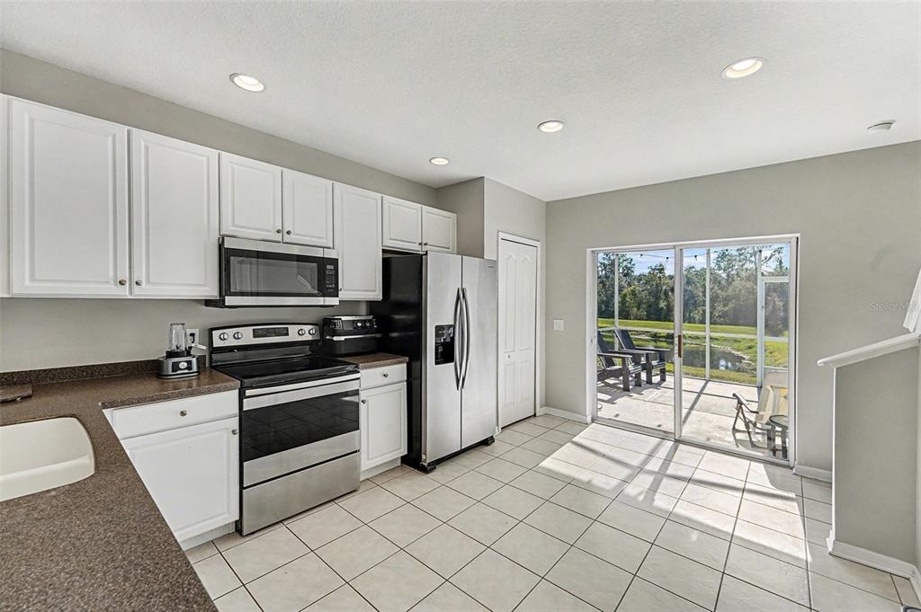 5860 Fishhawk Ridge Drive Lithia, FL 33547 - Photo 7 of 31 a kitchen with stainless steel appliances a stove a sink and a microwave