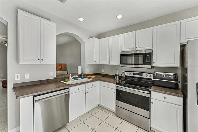 a kitchen with white cabinets appliances and a sink