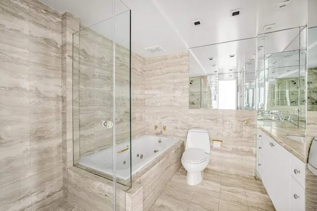 a bathroom with a bathtub shower sink mirror and toilet