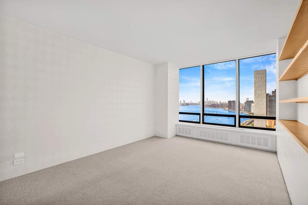 870 United Nations Plaza, Unit 28A Manhattan, NY 10017 - Photo 13 of 28 an empty room with sliding door