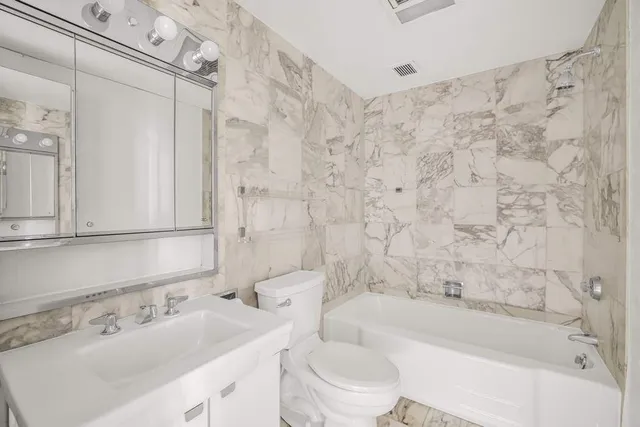a bathroom with a sink mirror toilet and bathtub