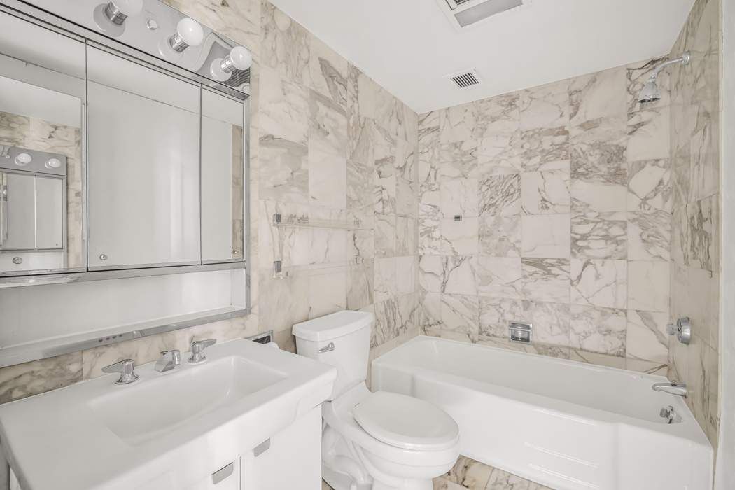870 United Nations Plaza, Unit 28A Manhattan, NY 10017 - Photo 15 of 28 a bathroom with a sink mirror toilet and bathtub