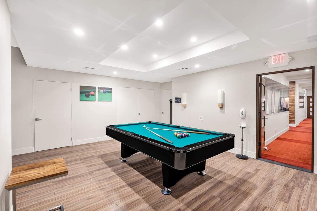 870 United Nations Plaza, Unit 28A Manhattan, NY 10017 - Photo 25 of 28 a room with pool table and wooden floor