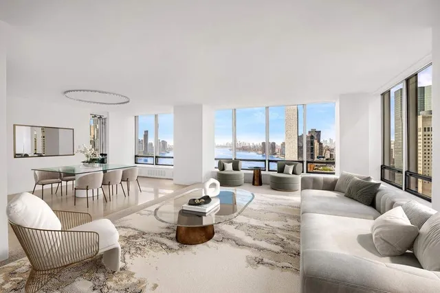 a living room with furniture and a floor to ceiling window