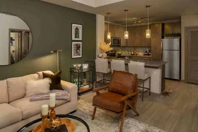 a living room with furniture a refrigerator and kitchen view