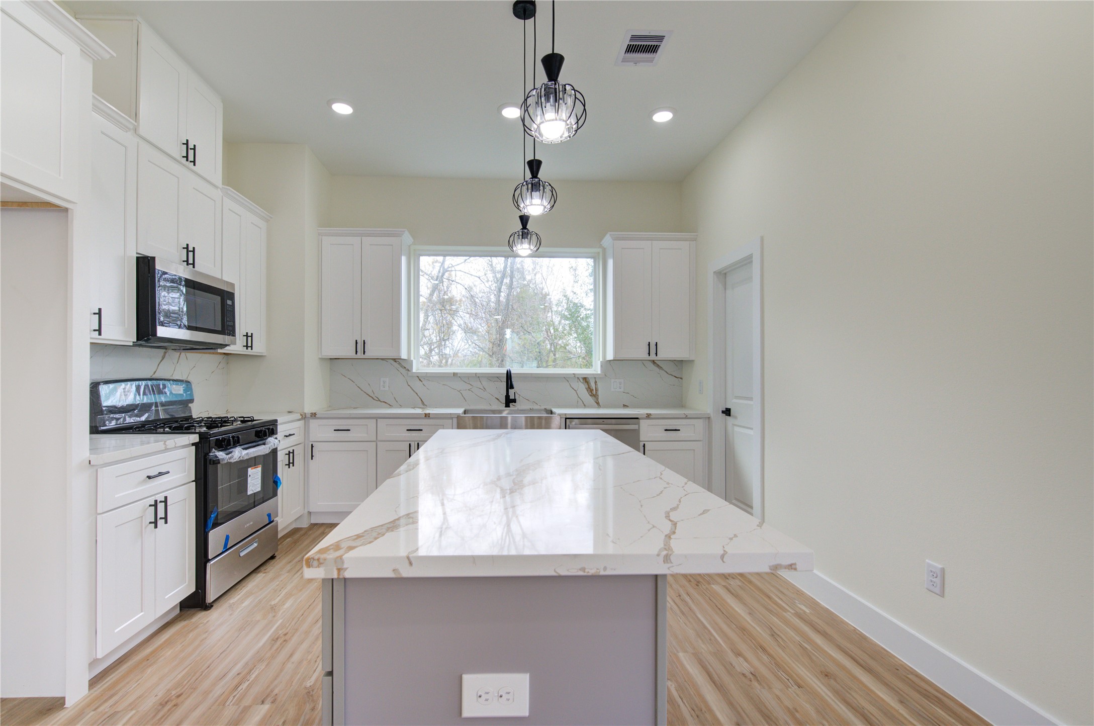 4308 Alice Street Houston, TX 77021 - Photo 17 of 25 a large kitchen with granite countertop a large island in the center and stainless steel appliances