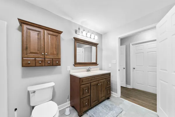 a bathroom with a toilet a sink and mirror