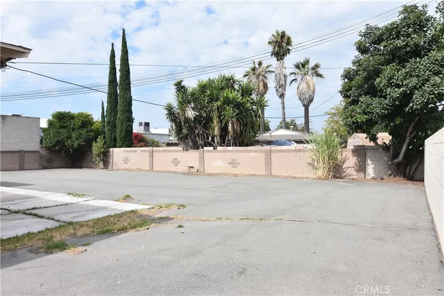a view of a dry yard with a building in the background