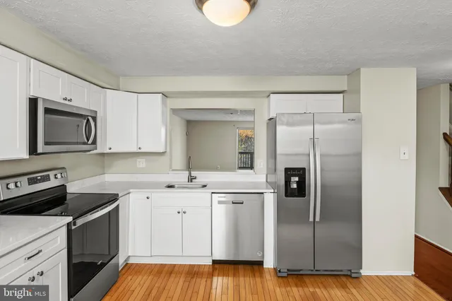 a kitchen with a refrigerator sink and cabinets