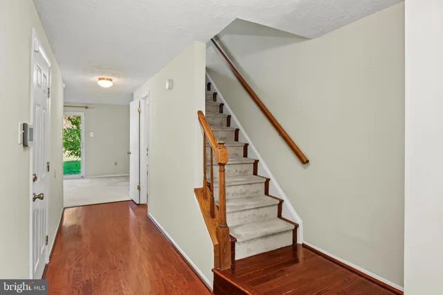 a view of a hallway with wooden floor and staircase