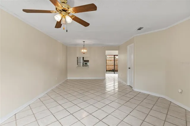 wooden floor in an empty room with a chandelier fan