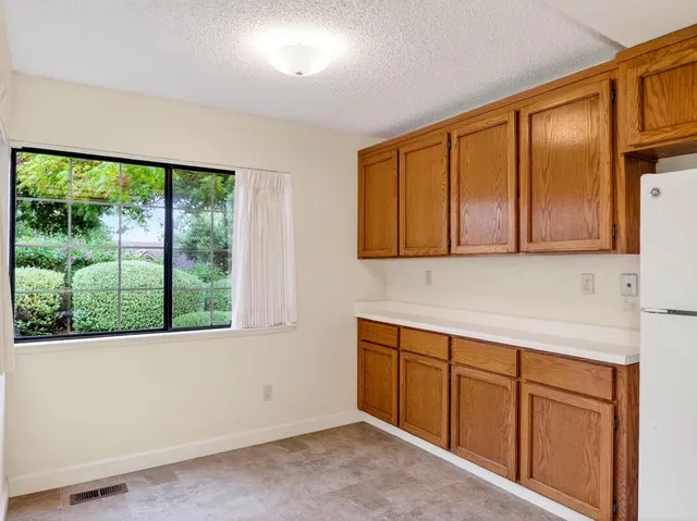 a view of a kitchen with wooden floor and cabinets