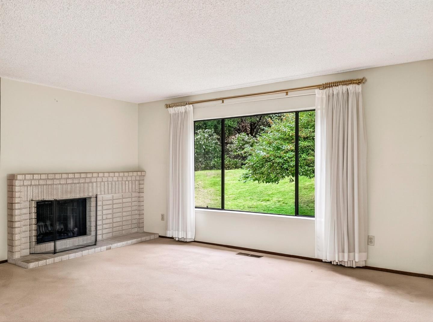 7391 Vía Cantares San Jose, CA 95135 - Photo 20 of 45 an empty room with floor a fireplace and a window