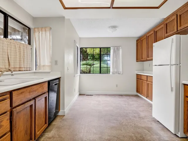 a view of a kitchen with a sink dishwasher and a refrigerator