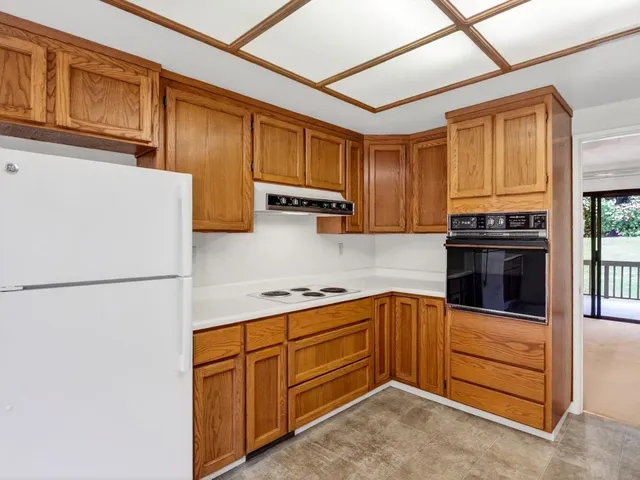 a kitchen with stainless steel appliances granite countertop a refrigerator stove a sink dishwasher and wooden cabinets