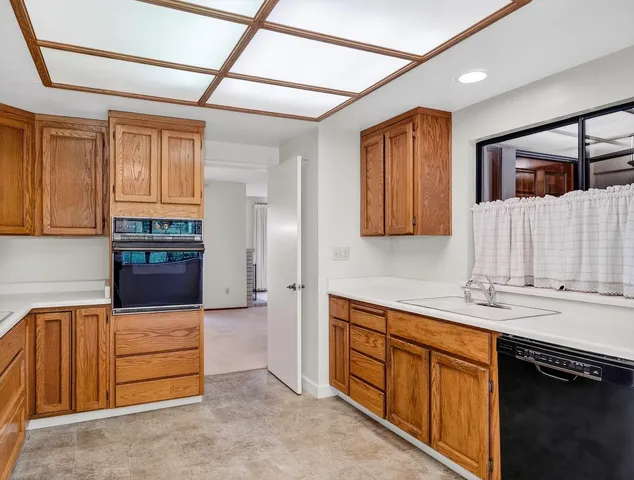 a kitchen with stainless steel appliances granite countertop a refrigerator and wooden cabinets