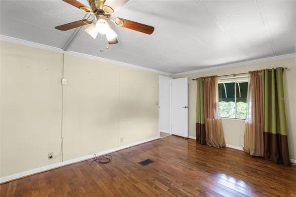 an empty room with wooden floor and a window
