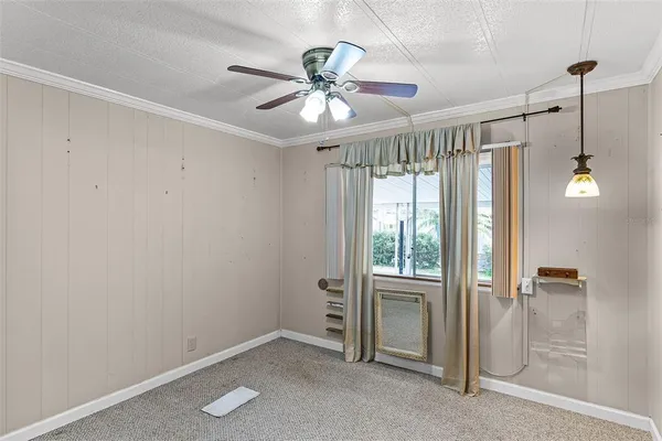 a view of a hallway with a livingroom and a chandelier fan