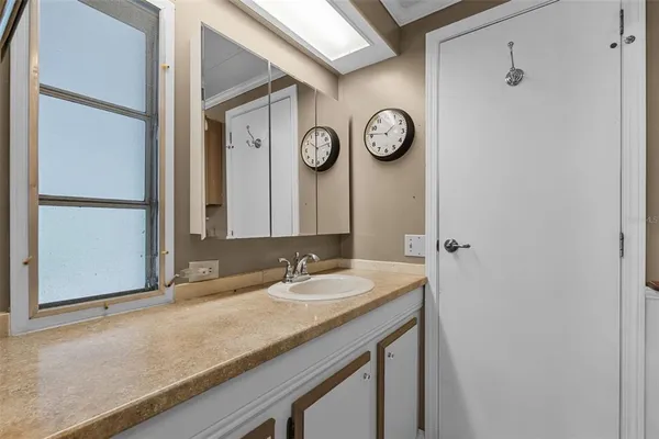 a bathroom with a granite countertop sink and a mirror