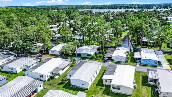 an aerial view of residential house with outdoor space and trees all around