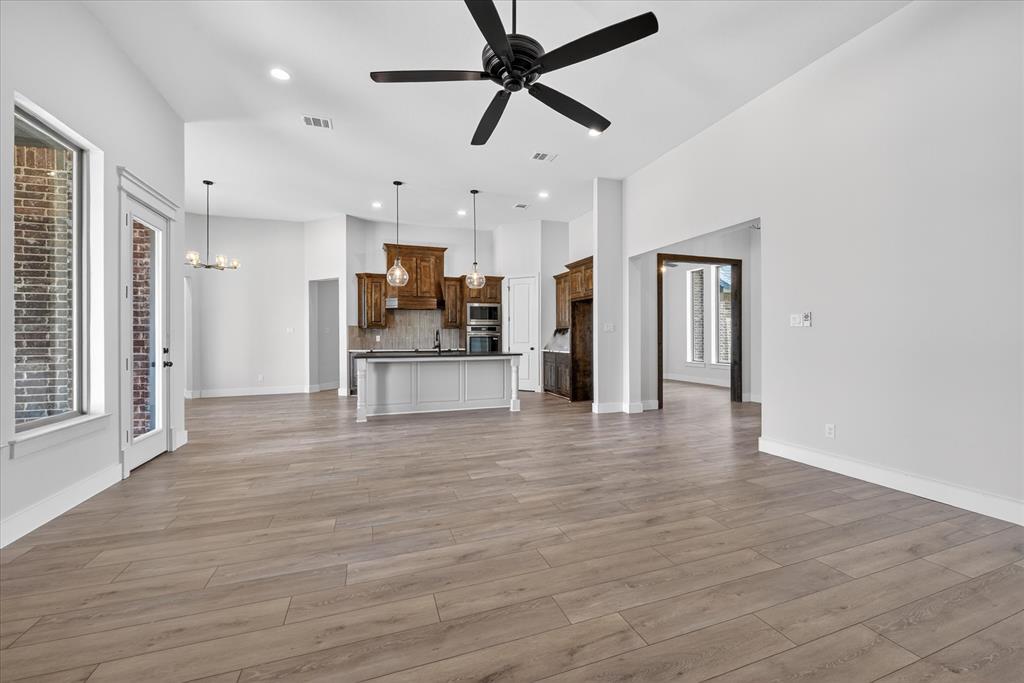 517 Longhorn Lane Springtown, TX 76082 - Photo 7 of 39 Unfurnished living room featuring hanging lights, ceiling fan, and light wood-style floors
