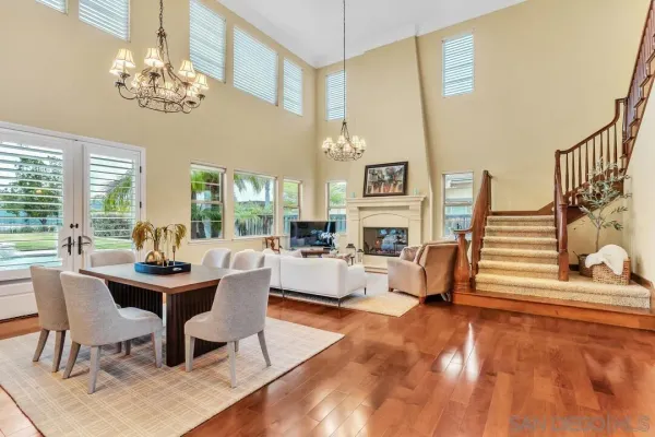 a dining room with furniture a chandelier and wooden floor