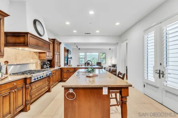 a kitchen with stainless steel appliances granite countertop a sink a stove and a refrigerator