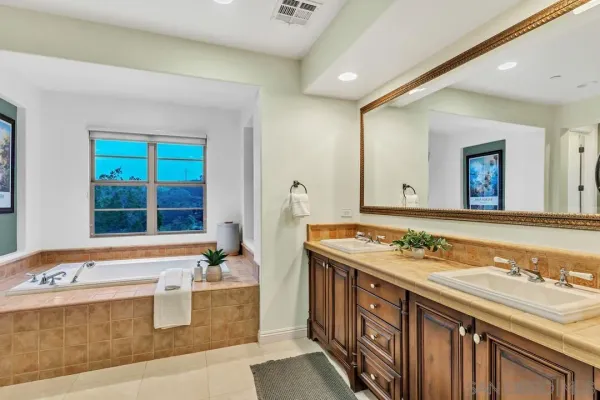 a bathroom with a granite countertop sink and a large mirror