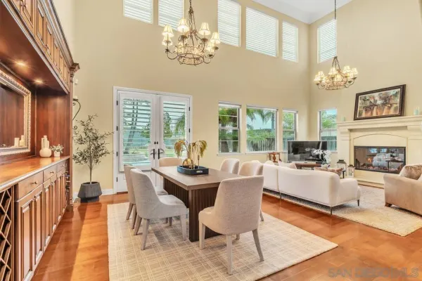 a view of a dining room with furniture a chandelier and wooden floor